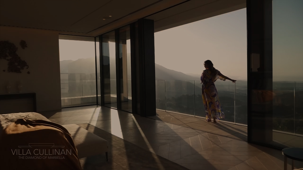 woman standing near large windows overlooking view